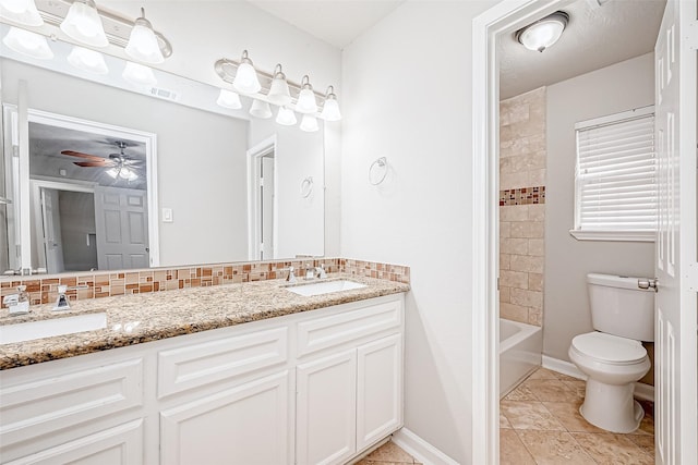 bathroom with ceiling fan, a sink, toilet, and decorative backsplash