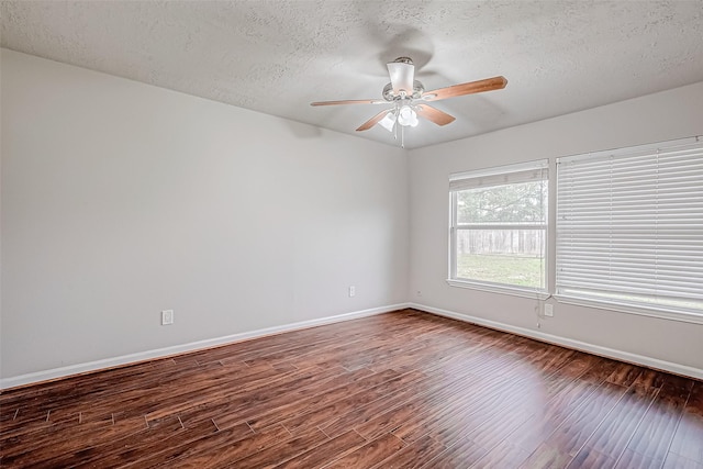 empty room featuring ceiling fan, a textured ceiling, baseboards, and wood finished floors