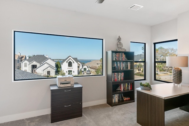 office space featuring baseboards, visible vents, and light colored carpet