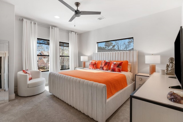 bedroom featuring a ceiling fan, visible vents, and light colored carpet