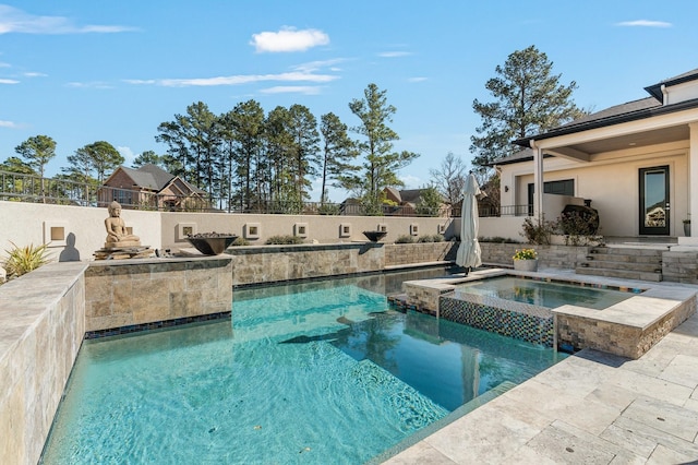 view of swimming pool with fence, a fenced in pool, and an in ground hot tub