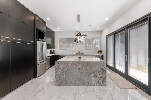 kitchen featuring recessed lighting, a kitchen island, marble finish floor, appliances with stainless steel finishes, and modern cabinets