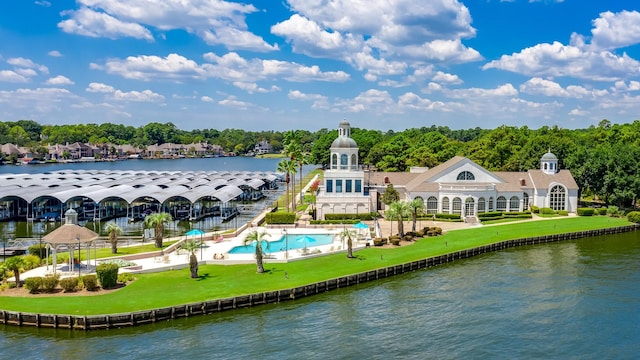 exterior space with a patio, a balcony, a water view, a lawn, and an outdoor pool