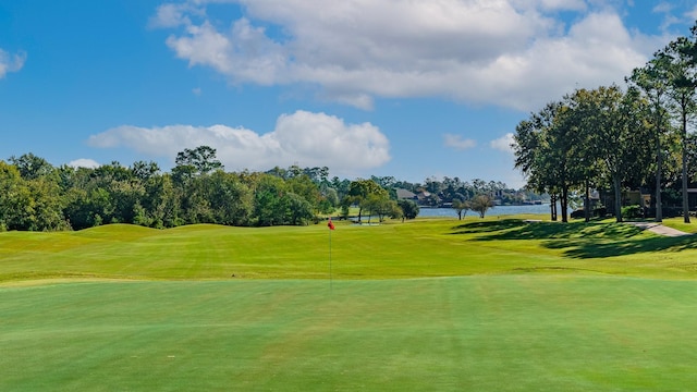 view of home's community featuring view of golf course, a water view, and a yard