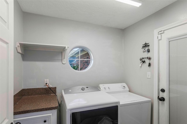 clothes washing area with washing machine and dryer, laundry area, and a textured ceiling