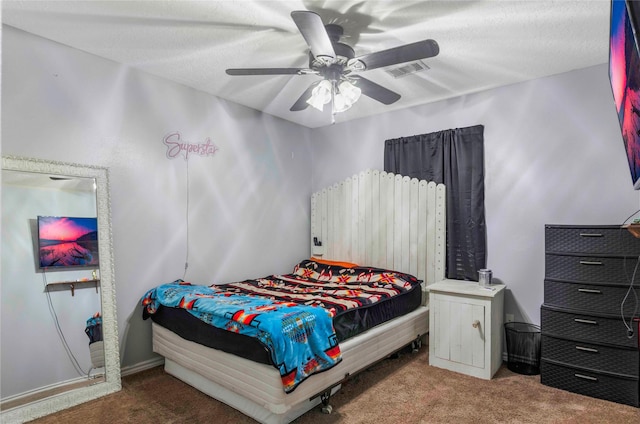 carpeted bedroom featuring ceiling fan, visible vents, and a textured ceiling