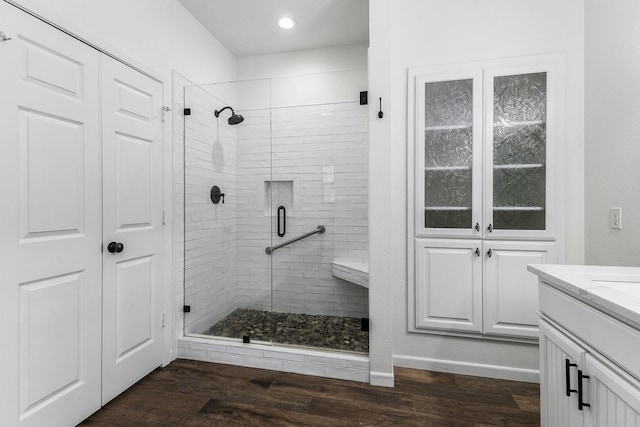 full bath with a stall shower, wood finished floors, and vanity