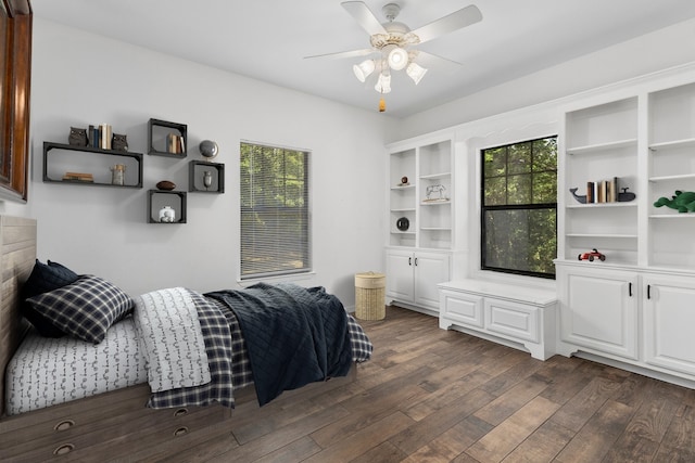 bedroom with multiple windows, dark wood finished floors, and ceiling fan