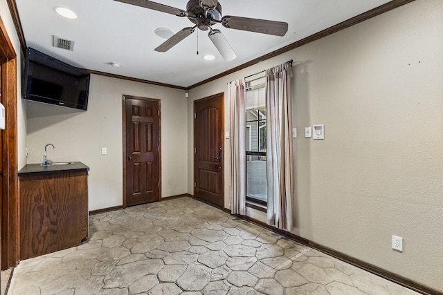 foyer with crown molding, visible vents, a ceiling fan, stone finish flooring, and baseboards