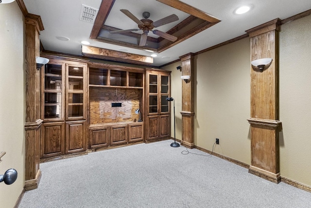 interior space with a tray ceiling, visible vents, ornamental molding, a ceiling fan, and light carpet