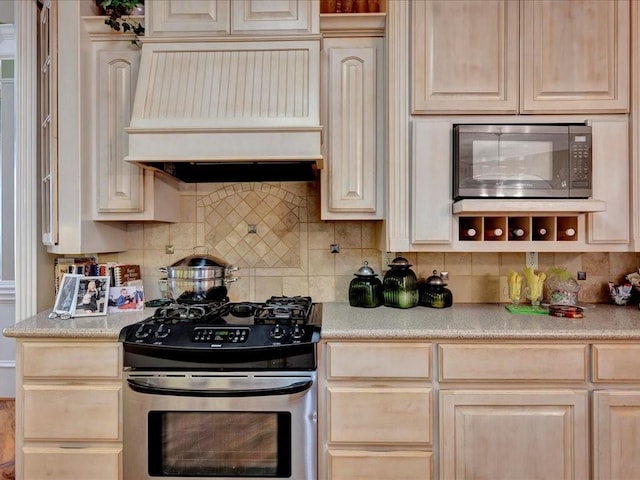 kitchen with black microwave, light countertops, stainless steel range with gas stovetop, and custom range hood