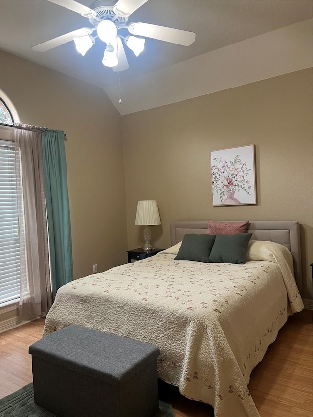 bedroom with lofted ceiling, a ceiling fan, and wood finished floors