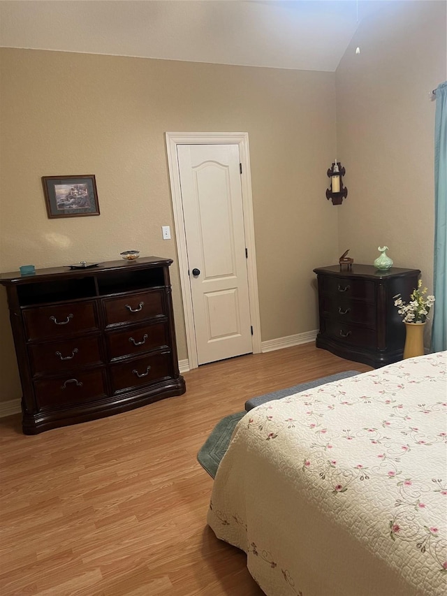 bedroom featuring light wood finished floors and baseboards