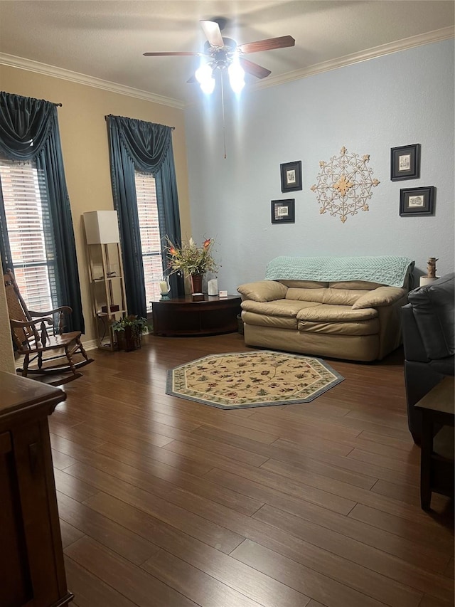 living area with dark wood-type flooring, crown molding, and ceiling fan