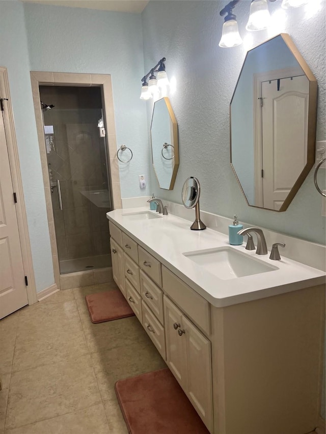 full bathroom with double vanity, a stall shower, tile patterned flooring, and a sink