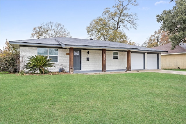 single story home with a garage, a front yard, brick siding, and driveway