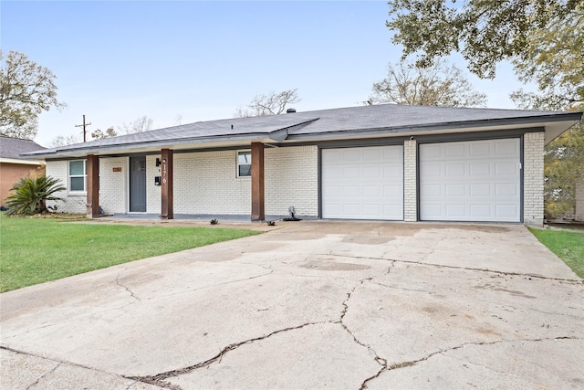 single story home featuring a garage, a front yard, concrete driveway, and brick siding