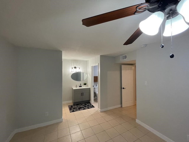 spare room with ceiling fan, light tile patterned floors, visible vents, and baseboards