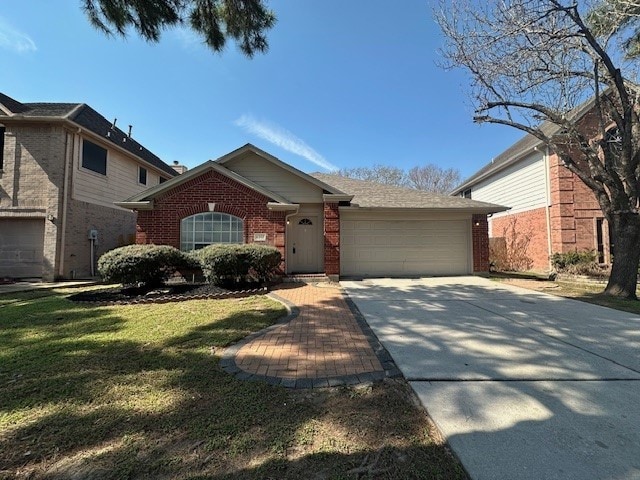 ranch-style home featuring an attached garage, a front yard, concrete driveway, and brick siding