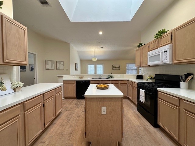 kitchen with a peninsula, light wood-style floors, light countertops, backsplash, and black appliances