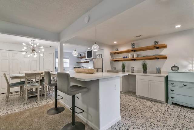 kitchen featuring open shelves, hanging light fixtures, a kitchen island, and light countertops