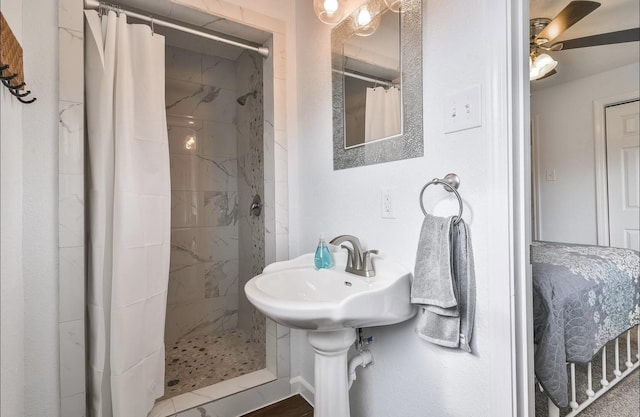 full bath featuring a ceiling fan and tiled shower