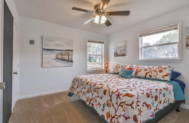 bedroom with a textured ceiling, carpet floors, a ceiling fan, and baseboards