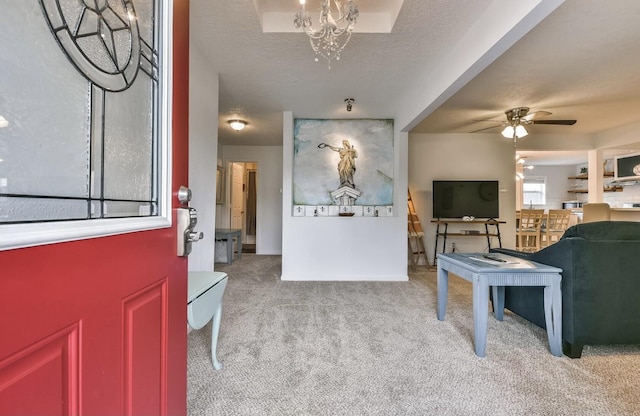 carpeted entrance foyer featuring a textured ceiling and ceiling fan