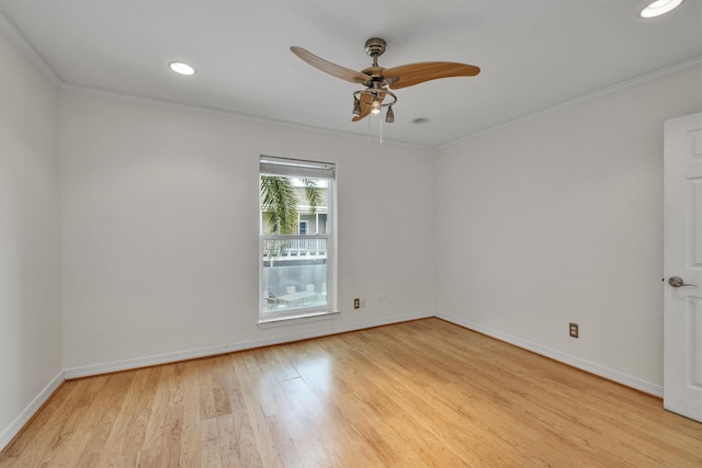 spare room with baseboards, light wood finished floors, and crown molding