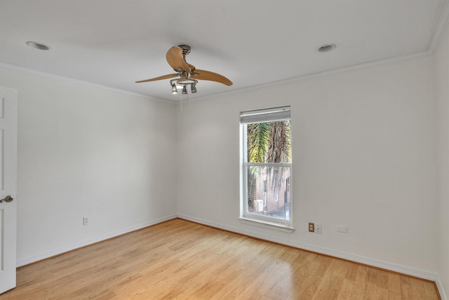 spare room featuring ornamental molding, baseboards, and wood finished floors