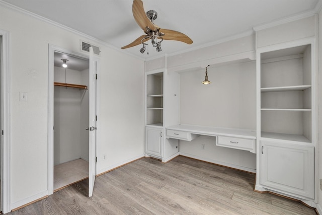 unfurnished office featuring ornamental molding, light wood-style flooring, built in study area, and visible vents