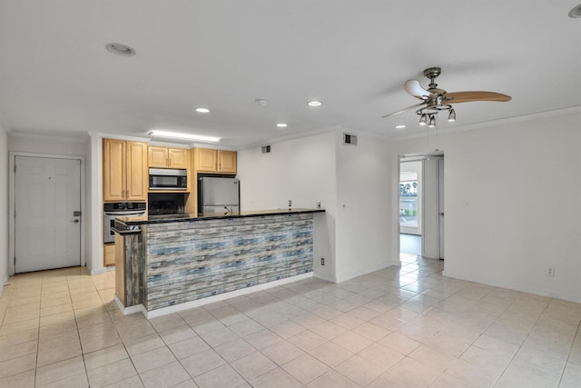 kitchen featuring dark countertops, appliances with stainless steel finishes, light tile patterned flooring, and crown molding