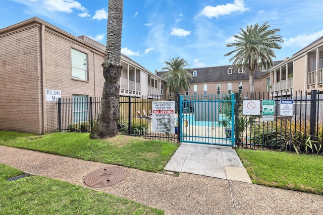 view of home's community featuring a gate, fence, and a lawn