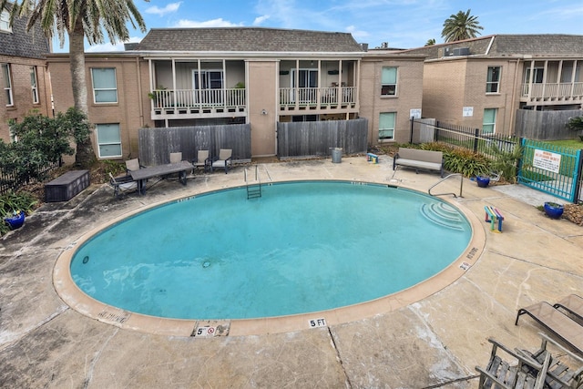 community pool featuring fence and a patio