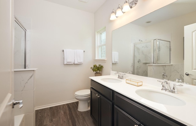 full bath with toilet, a sink, a marble finish shower, and wood finished floors