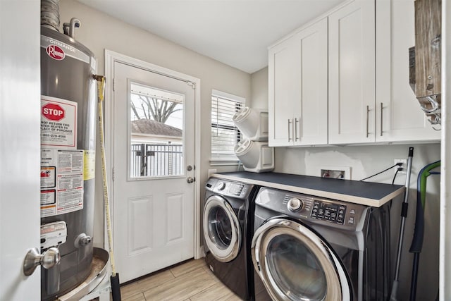 laundry room featuring cabinet space, washer and clothes dryer, gas water heater, and wood finish floors