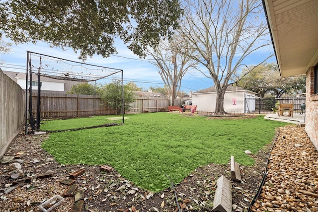 view of yard featuring a fenced backyard, a patio, and an outdoor structure