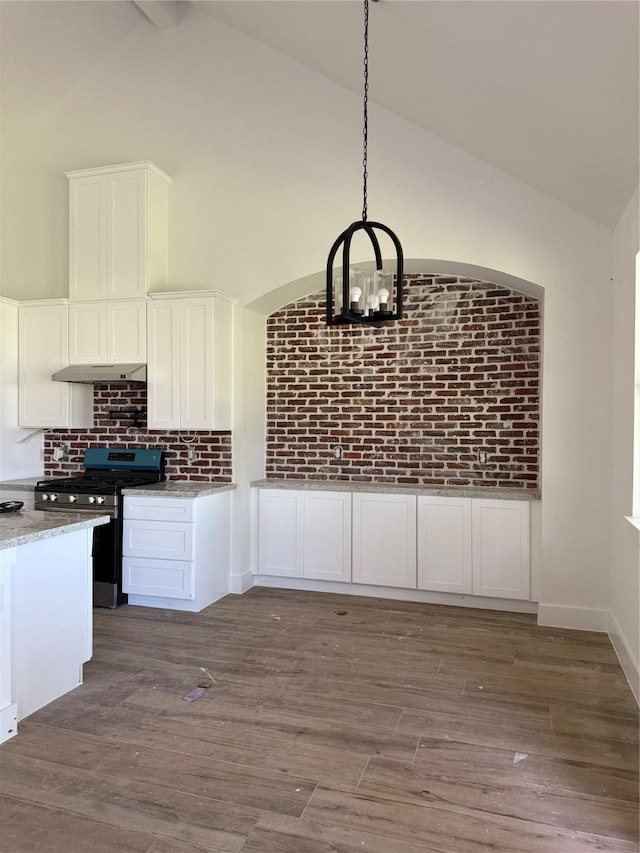 kitchen with stainless steel range with gas stovetop, dark wood finished floors, under cabinet range hood, and white cabinetry