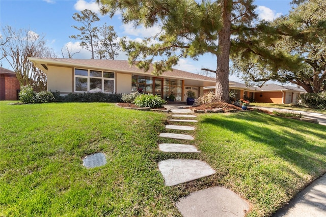 single story home featuring a front lawn and stucco siding