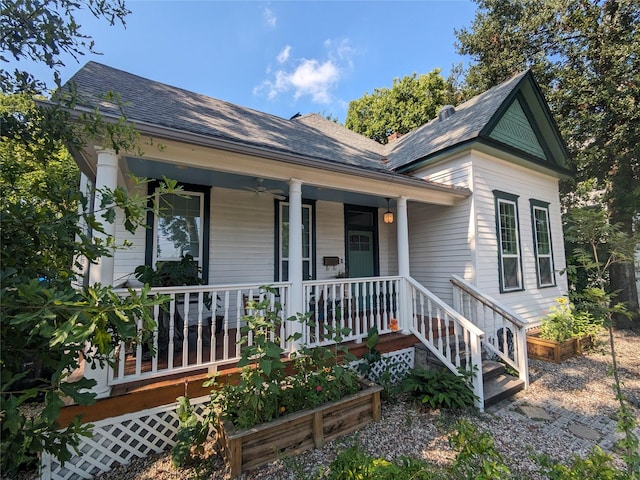 view of front of home featuring covered porch, roof with shingles, and a vegetable garden