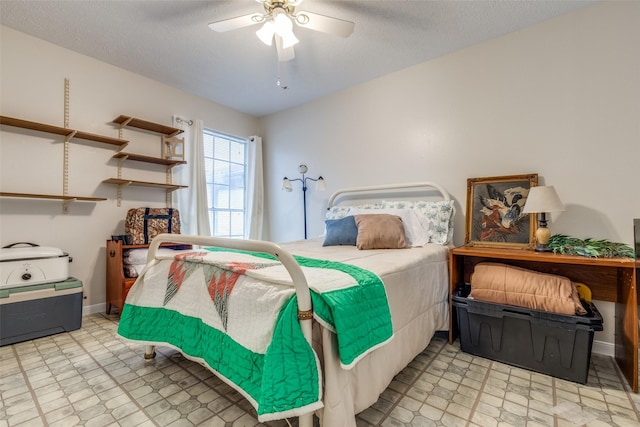 bedroom with ceiling fan, baseboards, a textured ceiling, and tile patterned floors