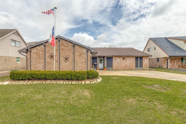 view of front of house with a patio area, a front yard, concrete driveway, and brick siding