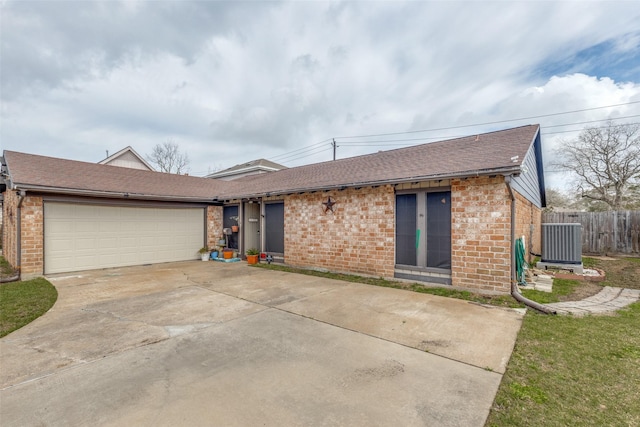 11439 Sageking Dr, Houston, TX 77089 - view of front of property featuring brick siding, a shingled roof, concrete driveway, a garage, and central AC unit