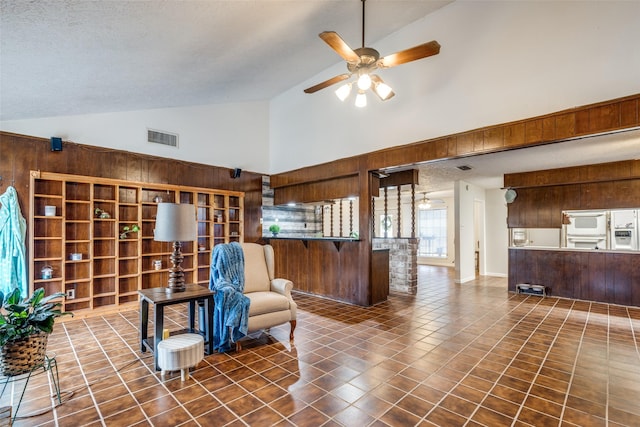 11439 Sageking Dr, Houston, TX 77089 - living area featuring wooden walls, high vaulted ceiling, and a ceiling fan