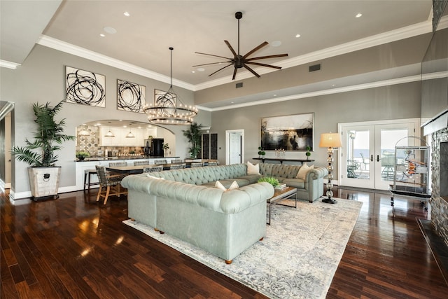 living area featuring visible vents, ornamental molding, dark wood-style flooring, a high ceiling, and french doors