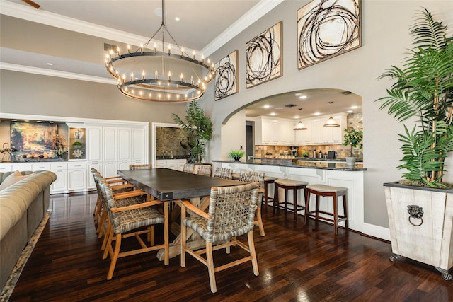 dining area with a towering ceiling, ornamental molding, arched walkways, and dark wood-style flooring