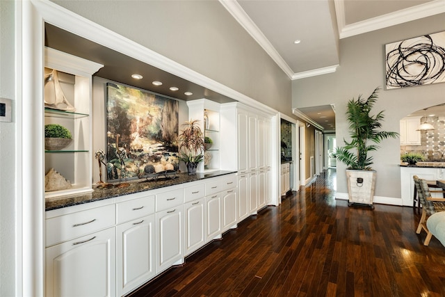 interior space featuring ornamental molding, dark wood-style flooring, and baseboards