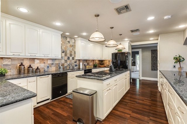 kitchen with dark wood finished floors, visible vents, a kitchen island, and black appliances