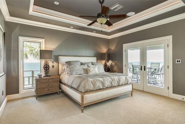 carpeted bedroom featuring visible vents, a raised ceiling, ornamental molding, access to outside, and french doors