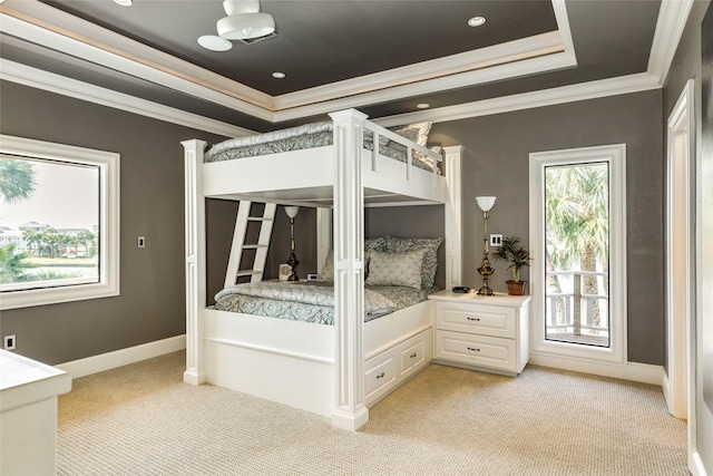 unfurnished bedroom with light carpet, baseboards, a tray ceiling, and crown molding